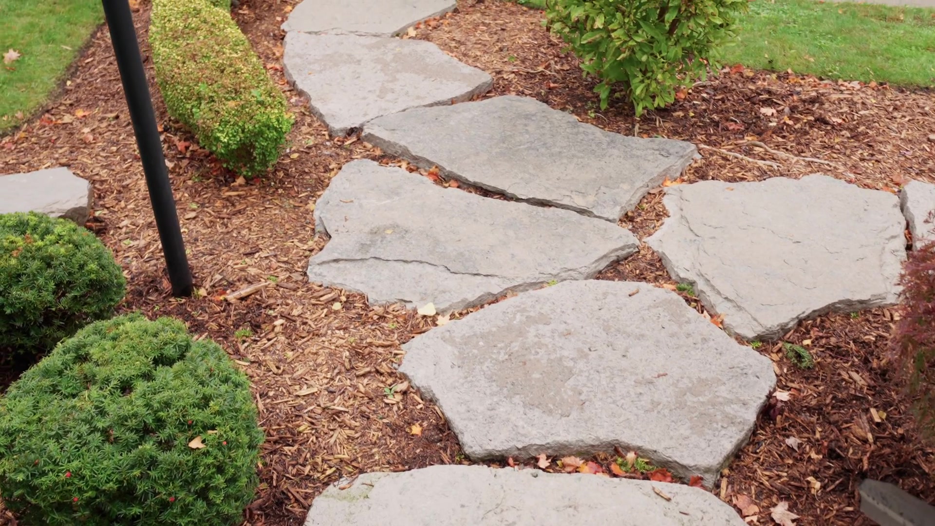 Stone pathway through mulched garden beds