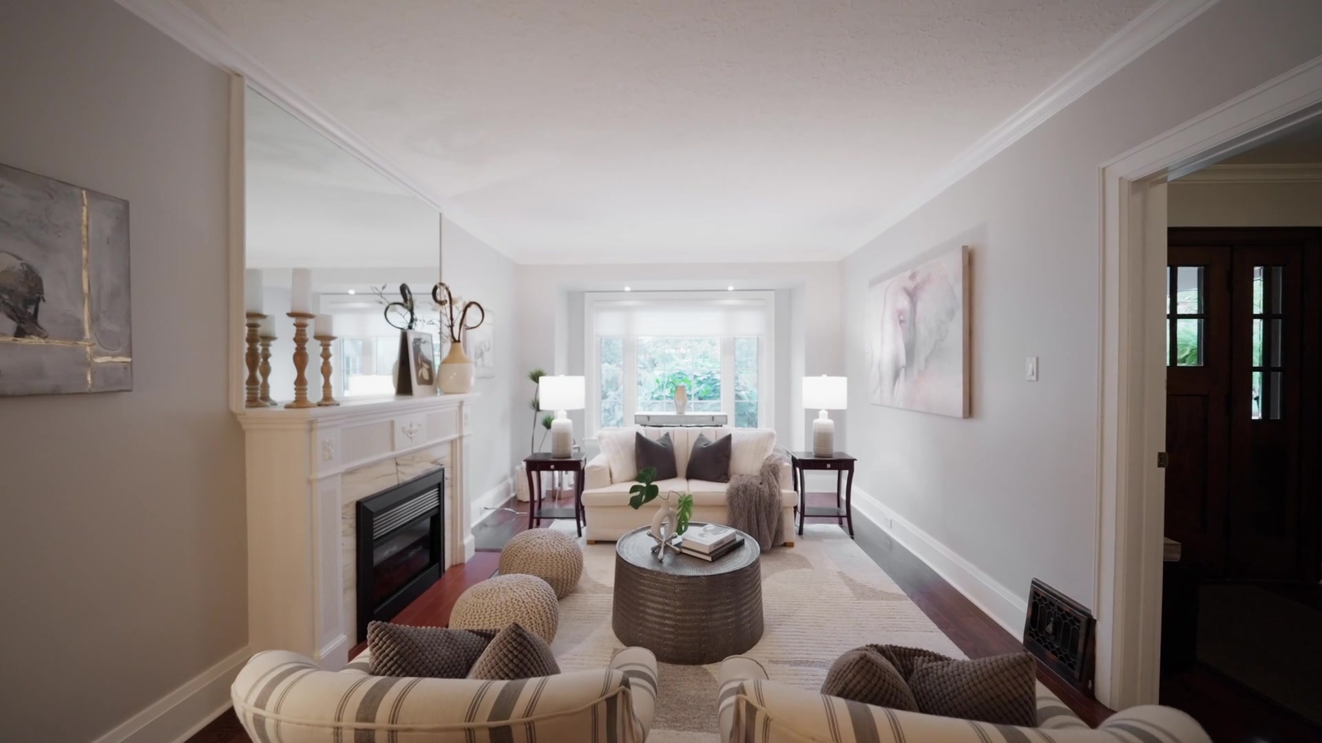 Formal living room with bay window and marble fireplace