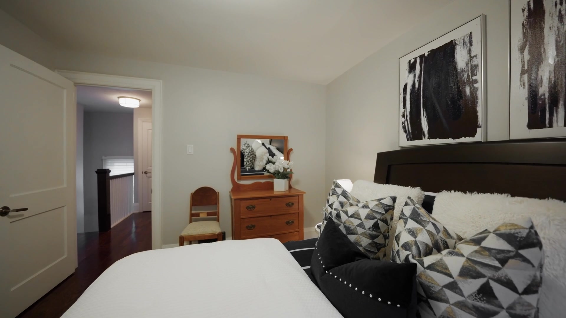 Primary bedroom with abstract art and patterned pillows