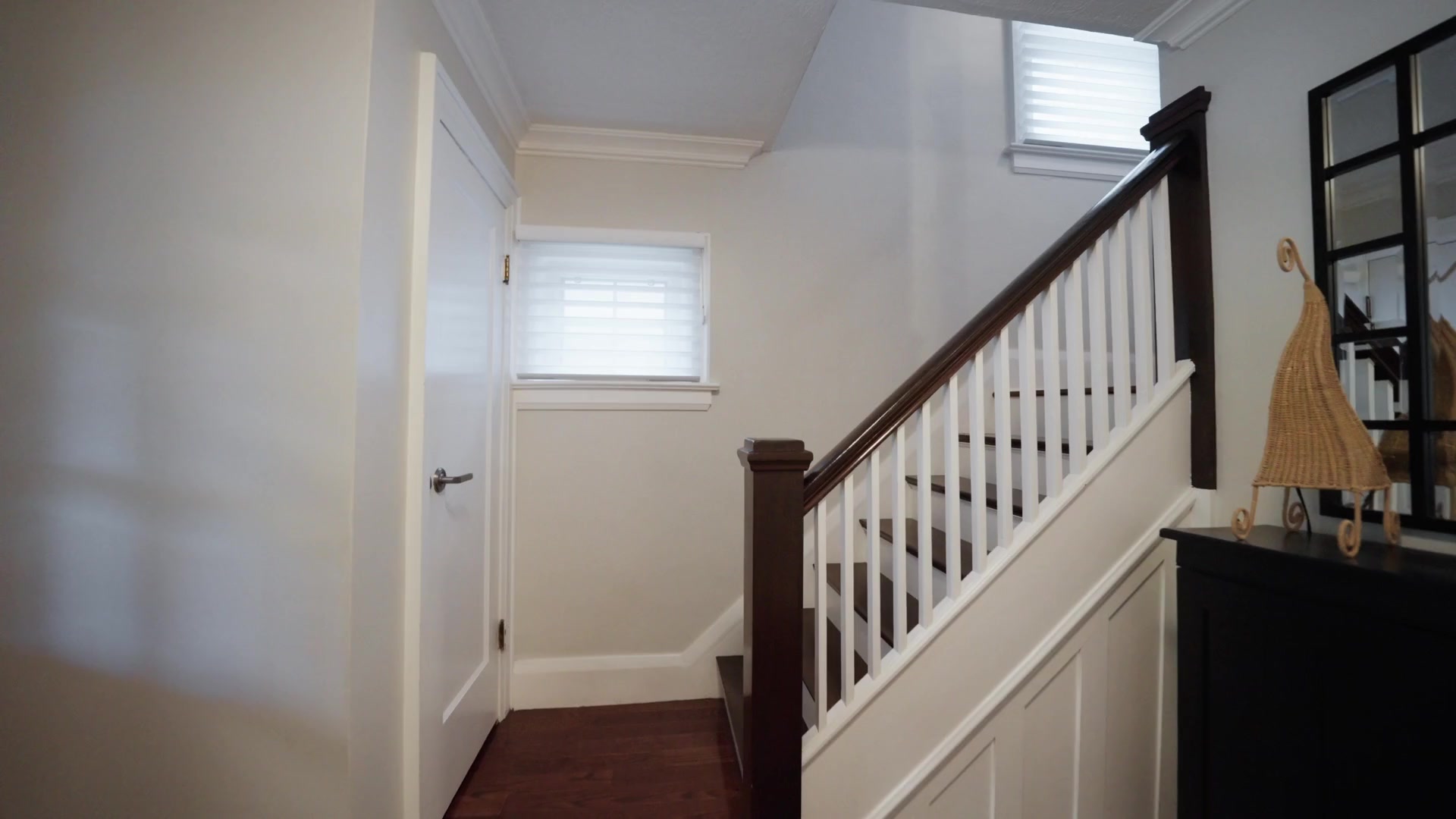 Staircase with white panelling and dark wood railing